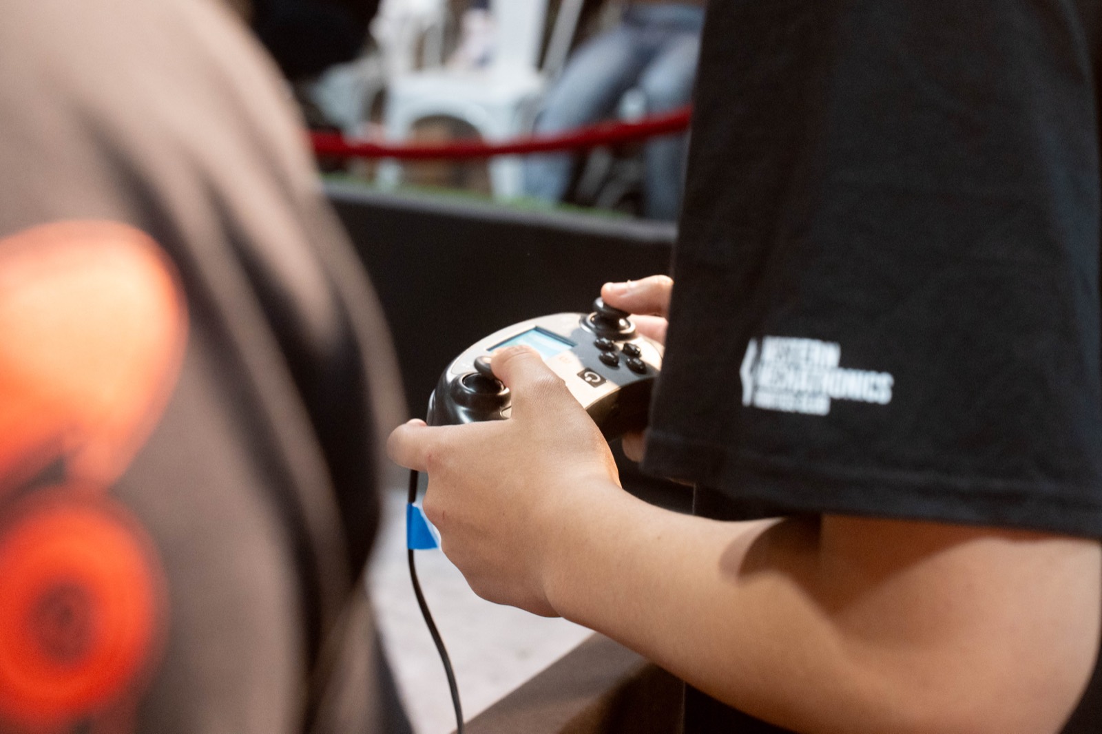 A student in a Western Mechatronics jersey driving a V5 robot with a controller